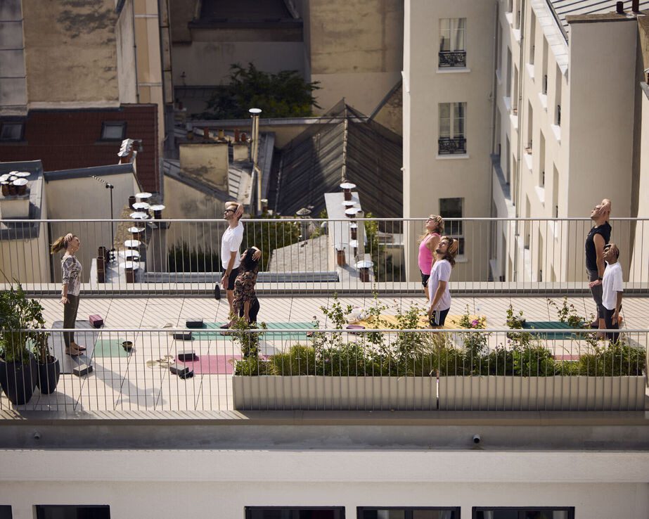 People participate in a rooftop yoga session.