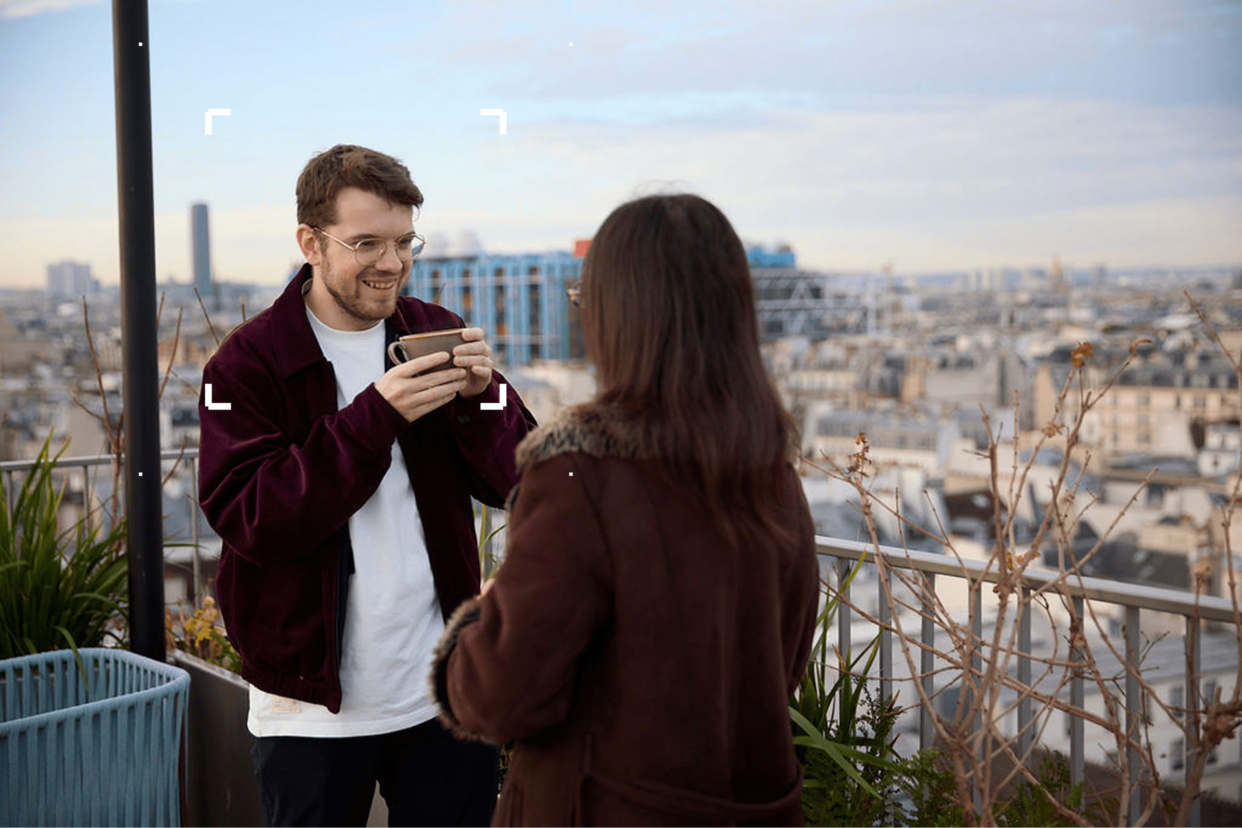 A man and a woman in individual work pods with a reflective image of the eiffel tower in the background