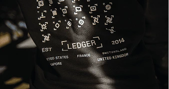 A close up of a hoodie with symbols and the ledger logo on it.